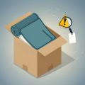 Isometric rolled mattress in a cardboard box with a warning triangle, a magnifying glass, and a blank care-label tag, on fiberglass in a mattress in a box